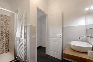un bagno bianco con lavandino e specchio di Ai Due Leoni 1863 a Ragusa