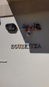 un cartel en una pared con animales de peluche. en B&B Eguzkitza, en Elgeta