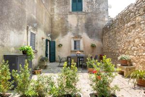 a courtyard in an old building with a table and chairs at Ai Due Leoni 1863 in Comiso