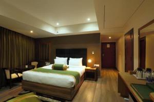 um quarto de hotel com uma cama grande e uma secretária em HOTEL SHOOLIN GRAND em Guwahati