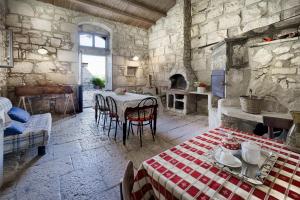 una stanza con tavolo e sedie in un edificio in pietra di Ai Due Leoni 1863 a Ragusa