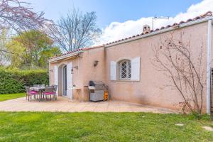 a patio with a table and chairs next to a building at Villa - Chez Dominique in Manosque