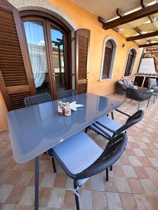 een blauwe tafel en stoelen op een patio bij Renabianca house in Santa Teresa Gallura