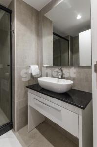 y baño con lavabo y ducha. en Luminous Two-bedroom Apartment In Trinidad, en Asunción