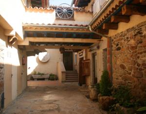 Une allée dans un bâtiment ancien avec des escaliers et une fenêtre dans l'établissement Casa Rural La Vertedera 3, à Villar de Ciervo