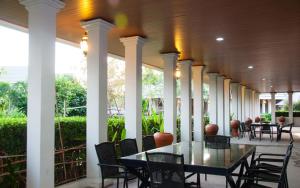 una mesa y sillas en un porche con columnas en PEARL RESORT AND HOTEL เพิร์ลรีสอร์ทแอนด์โฮเทล, en Ban Bang Phang