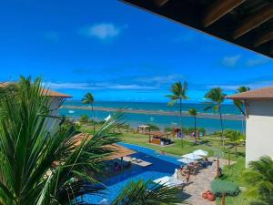 a view of a resort with a pool and the ocean at Polinésia resort em Porto de Galinhas Muro Alto - Acesso Total ao Samoa Beach Resort in Porto De Galinhas