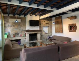 a living room with two couches and a fireplace at Casa Rural la Vertedera 2 in Villar de Ciervo