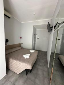 ein Schlafzimmer mit einem Bett mit zwei Handtüchern darauf in der Unterkunft Hotel Austria in Rimini