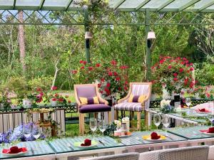 2 sillas y una mesa en un jardín con flores en Binh An Village Resort, en Da Lat