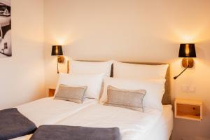- une chambre avec un lit blanc et 2 oreillers dans l'établissement Leitzach, à Fischbachau
