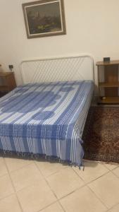 Bett in einem Zimmer mit einer blauen und weißen Decke in der Unterkunft Proprietà intero Allogio con parcheggio in Sestri Levante