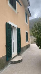 ein Gebäude mit grünen Fensterläden an der Seite in der Unterkunft Proprietà intero Allogio con parcheggio in Sestri Levante