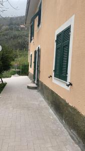 ein Gebäude mit grünen Türen an der Seite in der Unterkunft Proprietà intero Allogio con parcheggio in Sestri Levante