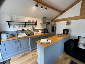 a kitchen with blue cabinets and a counter at Badgers Rest with free parking in Apperley Bridge