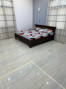 a bedroom with a bed and a tiled floor at Luxueuse cité in Bodjo