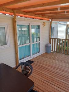 a screened porch with a table and chairs on a deck at Camping du Lac in Foix