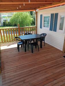 a patio with a table and chairs on a deck at Camping du Lac in Foix