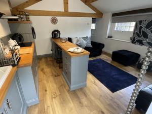 a kitchen and living room with a desk and a couch at Badgers Rest with free parking in Apperley Bridge