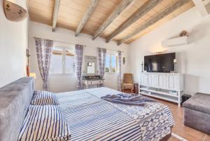 a bedroom with a bed and a couch and a television at Villa Christiane in Ses Salines