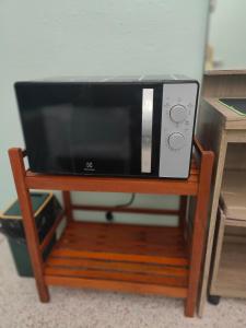 a microwave sitting on a wooden stand at 812 Quiet and Cozy Apartment in Bangkok