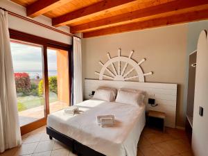 a bedroom with a large bed with a large window at Relais Rosa Dei Venti -Ciao Vacanze- in Moniga