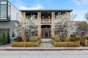 uma casa de tijolos com árvores floridas à sua frente em Comfy Apartment in Indianapolis em Indianápolis