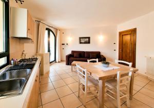 a kitchen and a dining room with a table and a couch at Leberides in La Maddalena