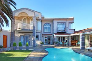 a house with a swimming pool in front of it at Atlantic Beach Villa in Cape Town