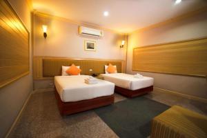 een hotelkamer met 2 bedden in een kamer bij PEARL RESORT AND HOTEL เพิร์ลรีสอร์ทแอนด์โฮเทล in Ban Bang Phang