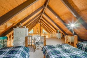 un dormitorio en el ático con 2 camas y una silla en Woodsy Cabin with Fire Pit about 8 Mi to Mount Snow, en Wardsboro