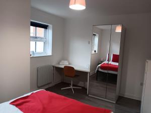 a bedroom with a desk and a mirror and a bed at Refúgio de charme no Peak District in Leek