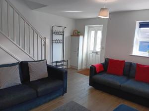 una sala de estar con 2 sofás y una escalera en Refúgio de charme no Peak District en Leek