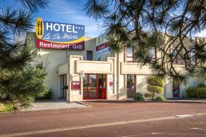 un edificio del restaurante spa del hotel con un cartel en Hotel Restaurant Le Sainte Mere, en Sainte-Mère-Église