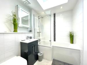 a bathroom with a sink and a tub and a shower at Renovated 2 Bedroom Apartment With 2 Bathrooms in Bristol