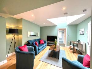 a living room with a blue couch and red pillows at Renovated 2 Bedroom Apartment With 2 Bathrooms in Bristol