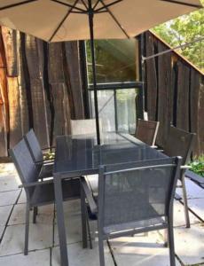 stół i krzesła z parasolem na patio w obiekcie Le Rustique Orford Domaine Cheribourg w mieście Magog-Orford