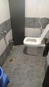 a bathroom with a white toilet in a stall at Hotel Sai Maa in Shirdi