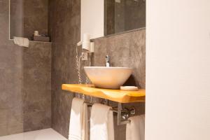 Hotel dell'Angelo في بريدور: حمام مع حوض على منضدة