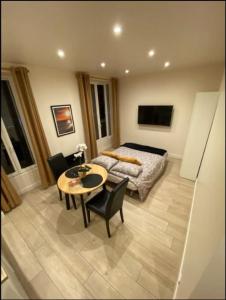 um quarto com uma cama, uma mesa e cadeiras em Studio cosy refait à neuf em Le Raincy