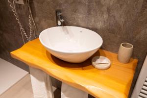 La salle de bains est pourvue d'un lavabo blanc sur une table en bois. dans l'établissement Hotel dell'Angelo, à Predore