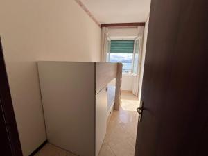 a small kitchen with a cupboard and a window at Appartamento La Nautica in Portoferraio