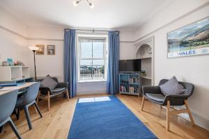 a living room with a desk and chairs and a window at Ground Floor Sea View Apartment in Aberdyfi