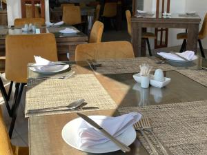 a table with plates and utensils on top of it at Cradle Mount Hotel in Krugersdorp