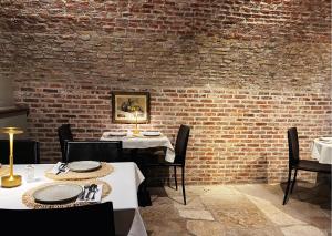 uma sala de jantar com duas mesas e uma parede de tijolos em Hotel Malleberg em Bruges