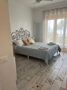 a bedroom with a bed and a large window at Villa Luisa B&B in Sperlonga