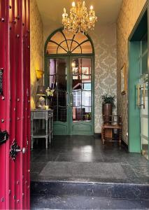 um quarto com uma porta verde e um lustre em Hotel Malleberg em Bruges