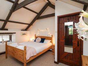 a bedroom with a bed and a wooden door at The Coach House in Haroldston West