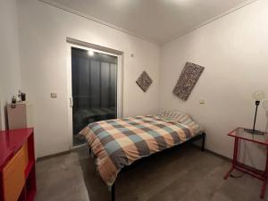 H Athens 3 bedrooms في أثينا: غرفة نوم مع سرير وبطانية منقوشة