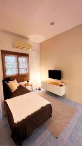 a bedroom with a bed and a flat screen tv at Alissia House in Koh Tao